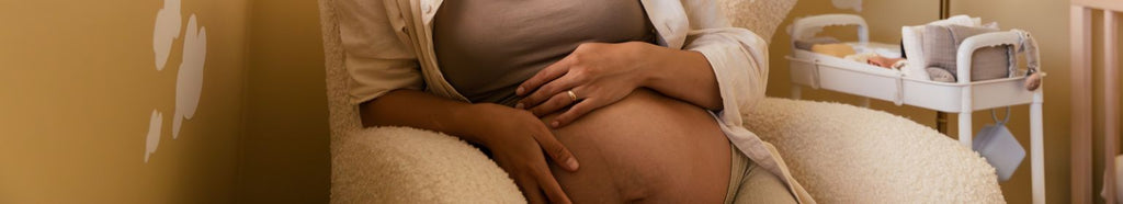 Pregnant woman holding a BIBS pacifier, preparing for parenthood,.